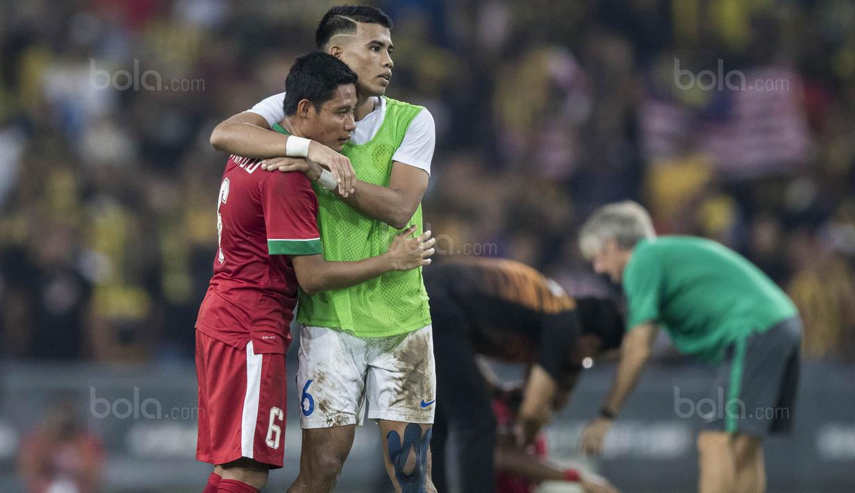 Pemain Malaysia menghibur kapten Timnas Indonesia, Evan Dimas, yang sedih karena kalah pada laga semifinal SEA Games di Stadion Shah Alam, Selangor, Sabtu (26/8/2017). Indonesia kalah 0-1 dari Malaysia. (Bola.com/Vitalis Yogi Trisna)