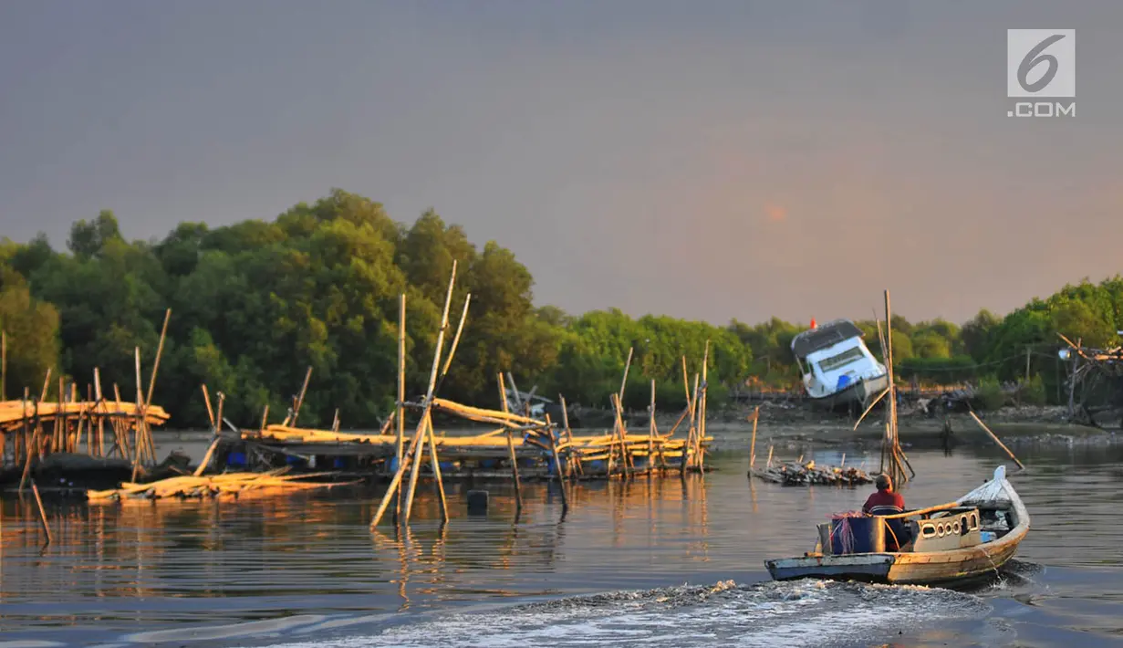 Nelayan melintasi area permukaan air laut yang menyurut di sekitar pesisir Kamal Muara, Jakarta, Kamis (15/3). Fenomena turunnya permukaan air di daerah ini semakin menyulitkan akses nelayan untuk pergi melaut. (Merdeka.com/Iqbal S Nugroho)