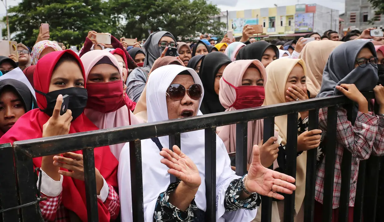 Warga menyaksikan eksekusi hukuman cambuk dua terpidana kasus liwath alias gay di Banda Aceh, Indonesia, (23/5). Dua orang pria tersebut menerima hukuman cambuk sebanyak 85 kali karena melakukan hubungan seks gay. (AP Photo / Heri Juanda, File)