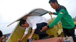 Presiden Jokowi mencoba mengoperasikan mesin panen padi buatan warga setempat, Faizal Chandoe di Kabupaten Pinrang, Sulawesi Selatan, Rabu (5/11/2014). (Rumgapres/Agus Suparto) 