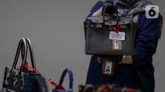 Petugas Komisi Pemberantasan Korupsi (KPK) menunjukkan salah satu tas mewah yang akan dilelang pada kegiatan Aanwijzing lelang barang rampasan hasil kasus korupsi yang ditangani di Rumah Penyimpanan Benda Sitaan Negara (Rupbasan), Jakarta, Kamis, (5/12/2024). (Liputan6.com/Herman Zakharia)