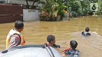 Sejumlah petugas menarik perahu karet saat proses evakuasi korban banjir di kawasan Pela Mampang Pulo, Jakarta, Kamis (2/1/2020). Sejumlah rumah di kawasan Pela Mampang Pulo terpantau masih terendam banjir. (Liputan6.com/Herman Zakharia)