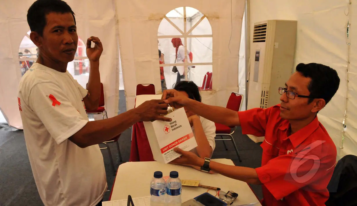 Petugas PMI memberikan bingkisan pada pendonor di acara Donor Darah Taruna Merah Putih di Bundaran HI, Jakarta, (29/3/2015). Acara donor darah diadakan serentak di 25 kota di tanah air bertujuan membudayakan aksi donor darah. (Liputan6.com/Panji Diksana)