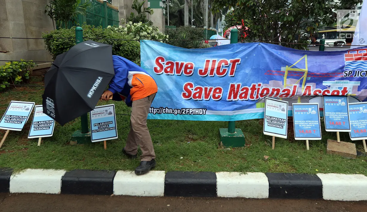 Serikat Pekerja JICT dan segenap pekerja pelabuhan Indonesia menggelar aksi di gedung DPR RI, Jakarta, Selasa (8/1). Dalam aksinya, pekerja membawa payung hitam dan simbol hitung mundur, tanda matinya keadilan bagi pekerja. (Liputan6.com/Johan Tallo)