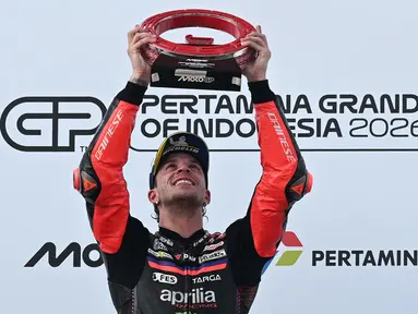 Pembalap Aprilia Racing asal Italia, Marco Bezzecchi, merayakan kemenangan di podium setelah menjuarai balapan MotoGP Indonesia di Sirkuit Internasional Mandalika, Mandalika, Minggu (11/10/2026). (SONNY TUMBELAKA/AFP)