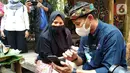 Menteri Parekraf Sandiaga Salahuddin Uno memesan alat pemarut di salah satu marketplace untuk ibu Lomin guna meningkatkan produksinya di Desa Wisata Bonjeruk, Kecamatan Jonggat, Lombok Tengah, NTT, Kamis (4/11/2021). (Liputan6.com/HO/Parekraf)