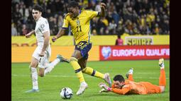 Striker Timnas Swedia, Anthony Elanga melewati kiper Azerbaijan, Emil Balayev pada laga Grup F Kualifikasi Euro 2024 di Friends Arena, Solna, Stockholm (27/3/2023). Saat menghadapi Azerbaijan, Anthony Elanga baru dimasukkan pada menit ke-87. Ia akhirnya mampu mencetak gol ketiga Swedia dua menit kemudian. (AFP/Fredrik Sandberg)