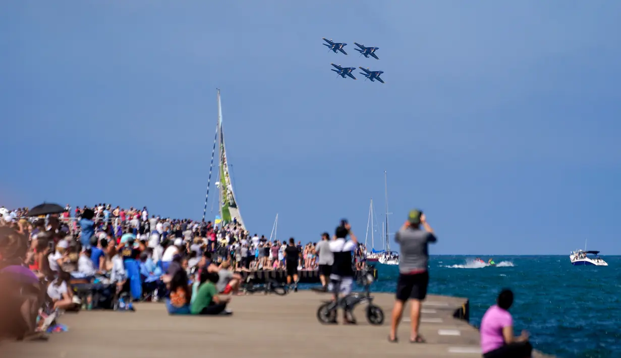 Pengunjung menyaksikan US Navy Blue Angels tampil pada Chicago Air and Water Show di atas Danau Michigan, Chicago, Amerika Serikat, 21 Agustus 2022. Chicago Air and Water Show diadakan setiap tahun sejak 1959. (AP Photo/Kiichiro Sato)