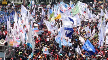 Kibaran bendera organisasi buruh mewarnai aksi perayaan hari Buruh Internasional di Kawasan Patung Patung Arjuna Wiwaha, Jakarta, Senin (5/1). Ribuan massa buruh ikut dalam perayaan Hari Buruh Internasional 2017. (Liputan6.com/Helmi Fithriansyah)