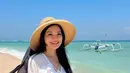 Saat liburan tersebut, Titi Kamal juga mengenakan mini dress putih dengan topi pantainya.[@marcella.zalianty/@titi_kamall]