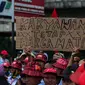 AMT (Awak Mobil Tangki) membawa poster saat melakukan mogok kerja dan unjuk rasa di Depot Pertamina Plumpang, Jakarta, Selasa (1/11). Mereka menuntut perusahaan menghapus sistem outsourcing dan membayar upah lembur mereka. (Liputan6.com/Faizal Fanani)