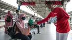 Petugas KAI Commuter (kanan) memberikan bunga dan healthy kit kepada perempuan pengguna KRL di Stasiun Jatinegara, Jakarta, Selasa (22/12/2020). Kegiatan tersebut dalam rangka memperingati Hari Ibu yang jatuh setiap tanggal 22 Desember. (Liputan6.com/Faizal Fanani)