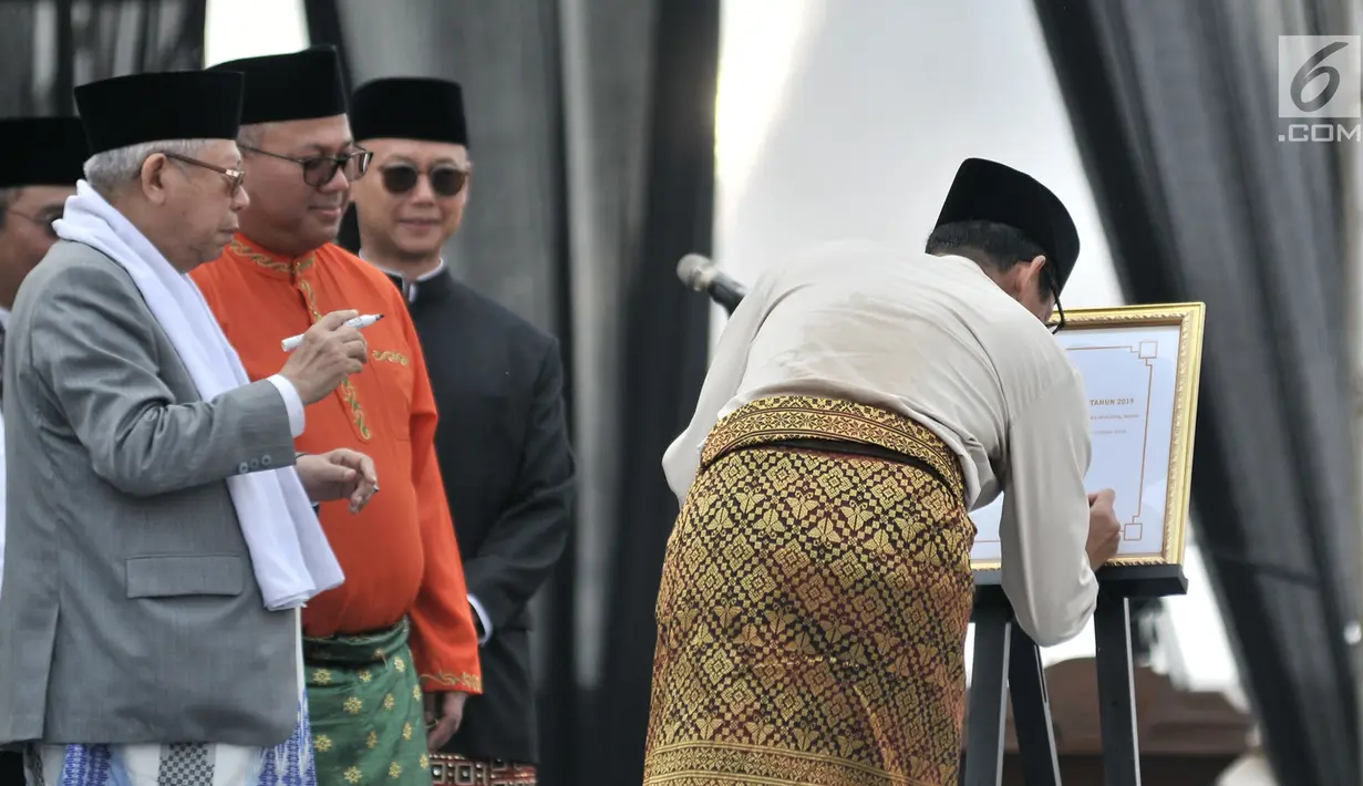 Calon wakil presiden nomor urut 02, Sandiaga Uno (kanan) menandatangani Deklarasi Kampanye Damai di Monas, Jakarta, Minggu (23/9). Deklarasi dihadiri pula oleh pimpinan partai pendukung kedua pasangan serta ribuan masyarakat. (Merdeka.com/Iqbal Nugroho)