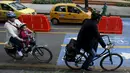 Dua orang pengguna sepeda melintas di persimpangan lampu merah selama "No Car Day" di Bogota, Kolombia (4/2/2016). Selama " No Car Day" Jalur ini juga dapat dilalui para pengguna sepatu roda dan skateboard. (REUTERS/John Vizcaino)