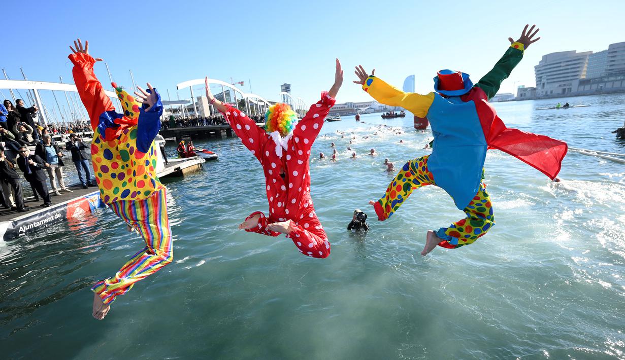 Para peserta menceburkan diri ketika mengikuti lomba renang unik saat natal di pelabuhan tua Barcelona (Port Vell Barcelona), Spanyol, Senin (25/12/2023) waktu setempat. (AFP/Josep Lago)