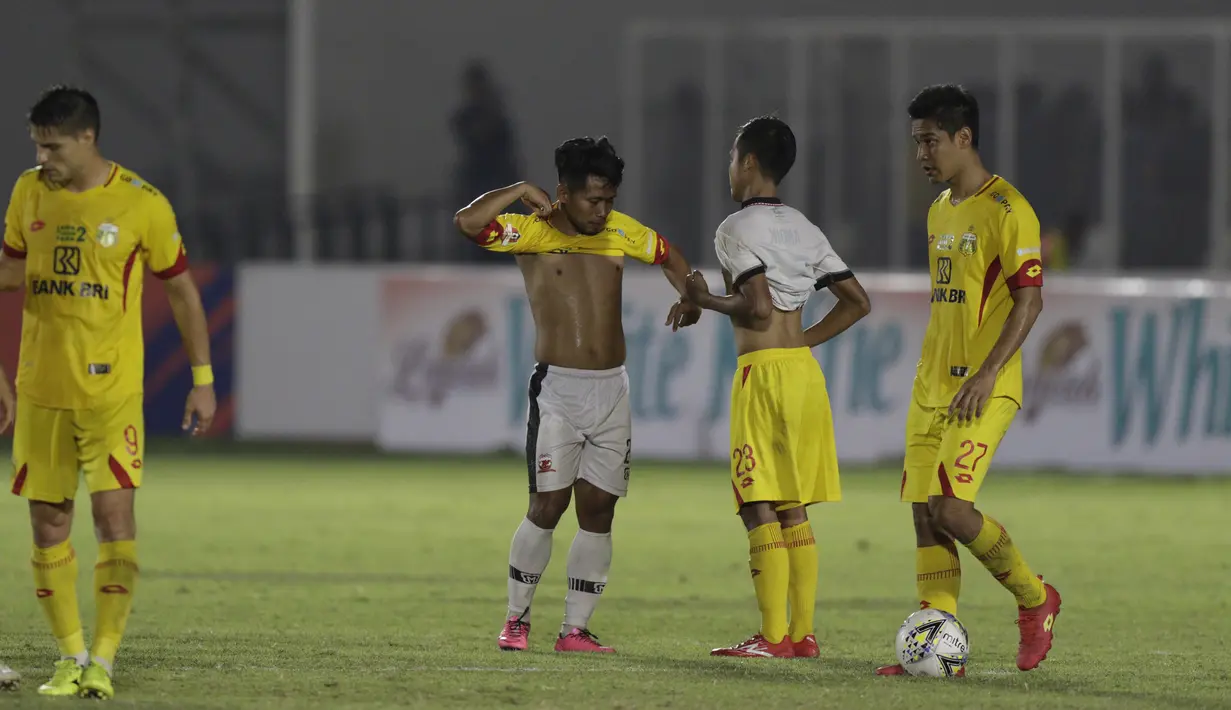Gelandang Madura United, Andik Vermansah, bertukar jersey dan celana dengan gelandang Bhayangkara FC, Wahyu Suboseto, pada laga Liga 1 2019 di Stadion Madya, Jakarta, Senin (5/8). Kedua tim bermain imbang 1-1. (Bola.com/M iqbal Ichsan)