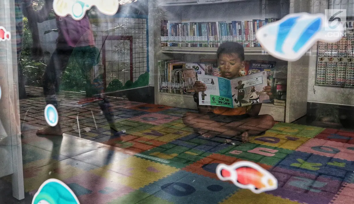 Seorang anak membaca buku di Ruang Perpustakaan RPTRA Kebon Sirih, Jakarta, Kamis (4/4). Gerakan Baca Jakarta ditujukan untuk anak-anak usia 7 hingga 12 tahun. (Liputan6.com/JohanTallo)