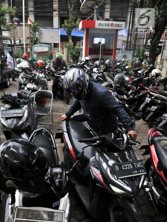 Pegawai kantor Balai Kota DKI Jakarta mengambil motor yang diparkir di halaman Kelurahan Kebon Sirih, Jakarta, Rabu (16/1). Naiknya tarif parkir di IRTI Monas juga menyebabkan halaman Kelurahan tersebut dipenuhi sepeda motor. (Merdeka.com/Iqbal S Nugroho)