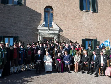 Paus Emeritus Benediktus XVI berfoto bersama delegasi dari Bavaria saat ulang tahunnya yang ke-90 di Vatikan (17/4). Ulang tahun Paus Benediktus bertepatan pada hari Minggu Paskah tahun ini.  (L'Osservatore Romano/Pool Photo via AP)