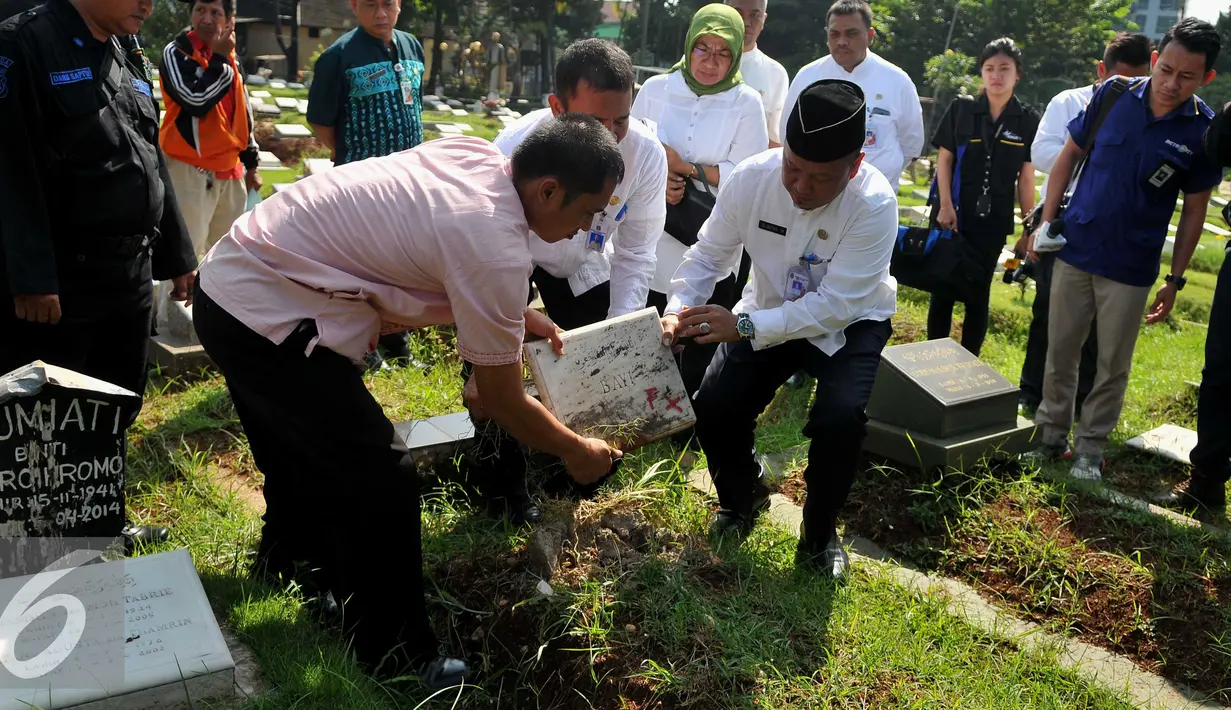 Kepala Dinas Pertamanan dan Pemakaman DKI Jakarta Djafar Muchlisin membongkar 4 makam dari total terindikasi 14 makam fiktif di Tempat Pemakaman Umum (TPU) Menteng Pulo, Jakarta Selatan, Kamis (28/7). (Liputan6.com/Gempur M Surya)