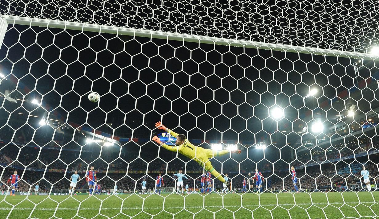 Kiper Basel, Tomas Vaclik (tengah) gagal menghalau bola sepakan pemain Manchester City, lkay Gundogan pada laga 16 besar Liga Champions di Saint Jakob-Park Stadium, Basel, (13/2/2018). Manchester City menang 4-0. (AFP/Patrick Hertzog)