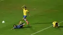 Striker Uruguay, Edinson Cavani, terjatuh saat perebutan bola dengan bek Brazil, Marquinhos. Kemenangan ini membuat Brasil semakin nyaman sebagai pemuncak klasemen sementara dengan koleksi 30 poin. (AFP/Pablo Porciuncula)