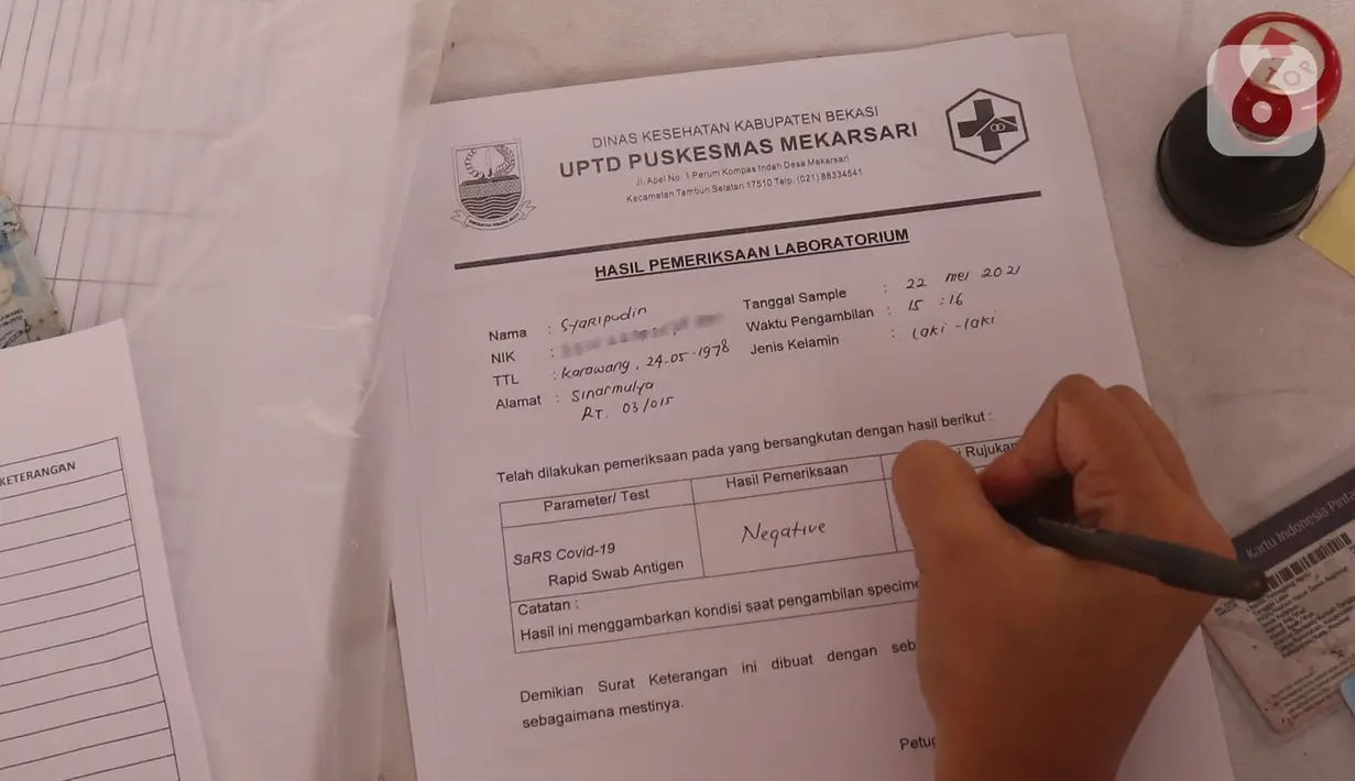Petugas menuliskan hasil pemeriksaan tes Swab antigen pengendara motor di pos pemeriksaan kesehatan, Cikarang, Bekasi, Sabtu (22/5/2021). Ada 14 orang dari 4.406 pemotor yang terindikasi positif COVID-19 berdasarkan tes Swab antigen pada arus balik 16-22 Mei 2021. (Liputan6.com/Herman Zakharia)