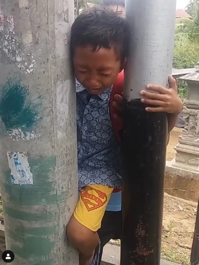 kepala bocah tersangkut di tiang listrik