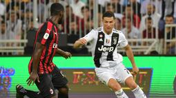 3. Cristiano Ronaldo mencoba melewati Christian Zapata pada laga Final Piala Super Italia yang berlangsung di stadion King Abdullah Sports City, Jeedah, Kamis (17/1). Juventus menang 1-0  atas AC Milan (AFP/Giuseppe Cacace)