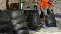 Sejumlah pekerja membungkus beras asal Vietnam dengan berat 10 Kilogram per kantong untuk Operasi Pasar (OP), di Gudang Bulog, Pekanbaru, Riau. (Antara)