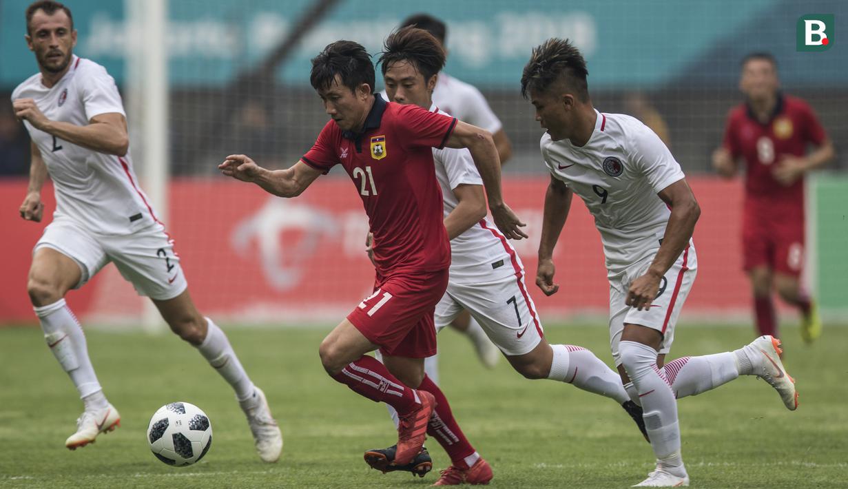 Gelandang Laos, Bounmalay Tiny, berusaha melewati kepungan pemain Hongkong pada laga Grup A Asian Games di Stadion Patriot, Jawa Barat, Jumat (10/8/2018). Hongkong menang 3-1 atas Laos. (Bola.com/Vitalis Yogi Trisna)