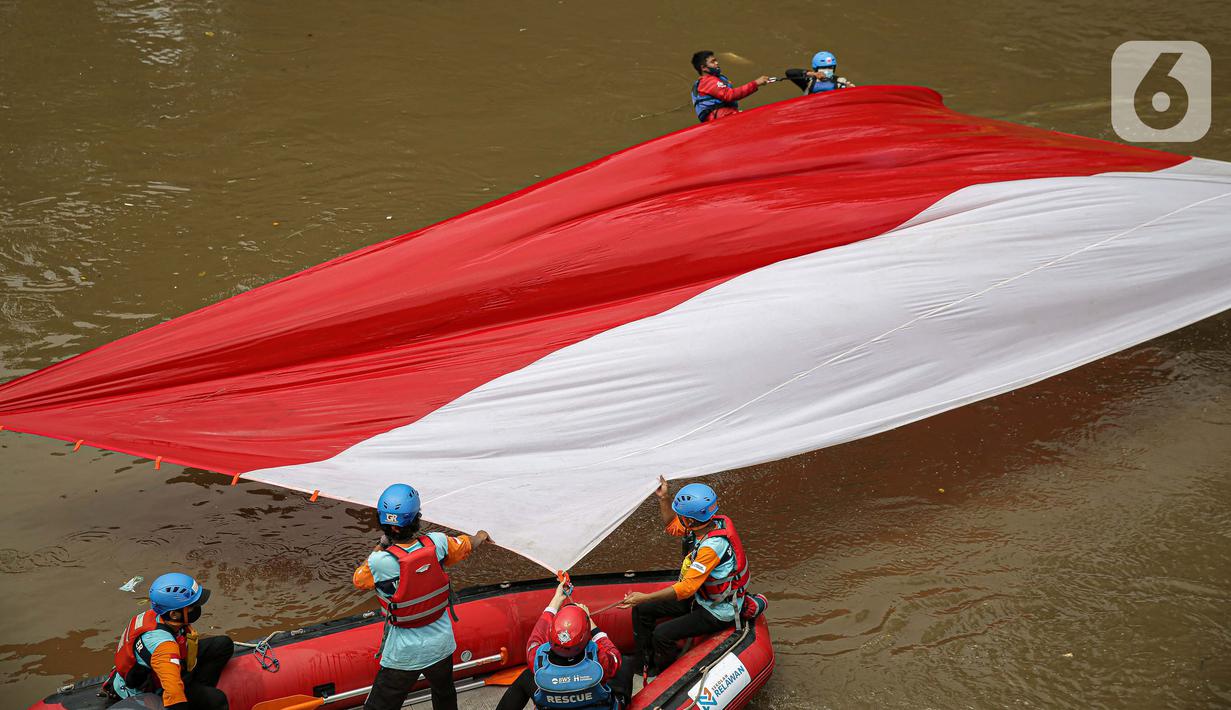 Sejumlah relawan membentangkan bendera Merah Putih di aliran kali
Ciliwung di kawasan Sudirman, Jakarta, Minggu (22/8/2021). Pembentangan atau pengibaran bendera Merah Putih tersebut dilaksanakan untuk memperingati HUT ke-76 RI. (Liputan6.com/Faizal Fanani)