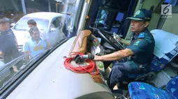 Petugas BPTD wilayah Banten Kementerian Perhubungan memeriksa bagian kemudi bus di Pool Blue Star, Pondok Cabe, Rabu (30/5). Pengecekan ini dilakukan untuk memastikan kelayakan armada bus yang akan digunakan untuk mudik lebaran. (Merdeka.com/Arie Basuki)