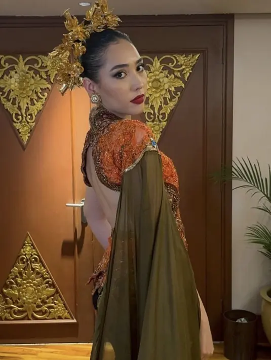 Lalu Laksmi tampil anggun dibalut kebaya brokat backless warna orange ditambah selendang hijau dari Anne Avantie. [@laksmideneefe]