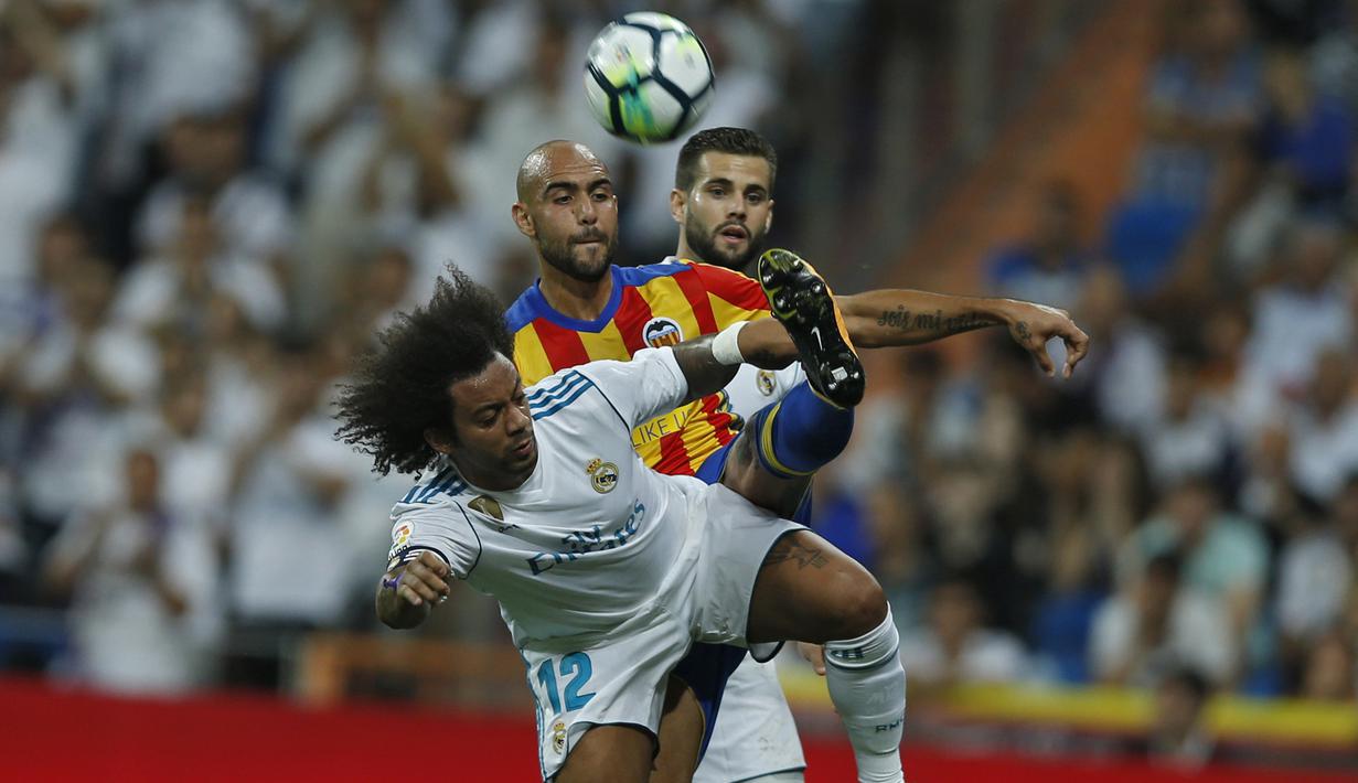 Pemain Real Madrid, Marcelo (depan) menutup pergerakan pemain Valencia, Simone Zaza pada lanjutan La Liga Spanyol di Santiago Bernabeu stadium, Madrid, (27/8/2017). Real ditahan Imbang 2-2. (AP/Francisco Seco)