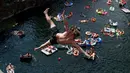 Penonton menyaksikan peserta terjun ke dalam air selama kompetisi melompat dari tebing di dekat desa Hrimezdice, Republik Ceko, 3 Agustus 2018. Kegiatan ini menjadi sebuah olahraga yang ditandai dengan keberanian, sensasi dan resiko. (AP/Petr David Josek)