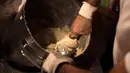 Karyawan mengaduk adonan donat khas Spanyol atau churros di restoran dessert tradisional La Manueta, Pamplona, Spanyol, Rabu (10/7/2019). Kue ini memiliki bahan utama tepung terigu dan dibentuk sedemikian rupa sehingga berbentuk memanjang. (JAIME REINA/AFP)