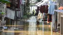 Warga beraktifitas saat banjir merendam pemukiman di Jalan Pirus, Kelurahan Bidara Cina, Jatinegara, Jakarta Timur, Minggu (6/7/2025). (merdeka.com/Arie Basuki)