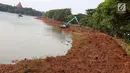 Pemandangan saat alat berat mengeruk lumpur di kawasan Setu Babakan, Jakarta, Senin (7/5). Selain untuk menambah daya tampung air, pengerukan juga sebagai salah satu langkah pencegahan banjir di Ibu Kota. (Liputan6.com/Immanuel Antonius)