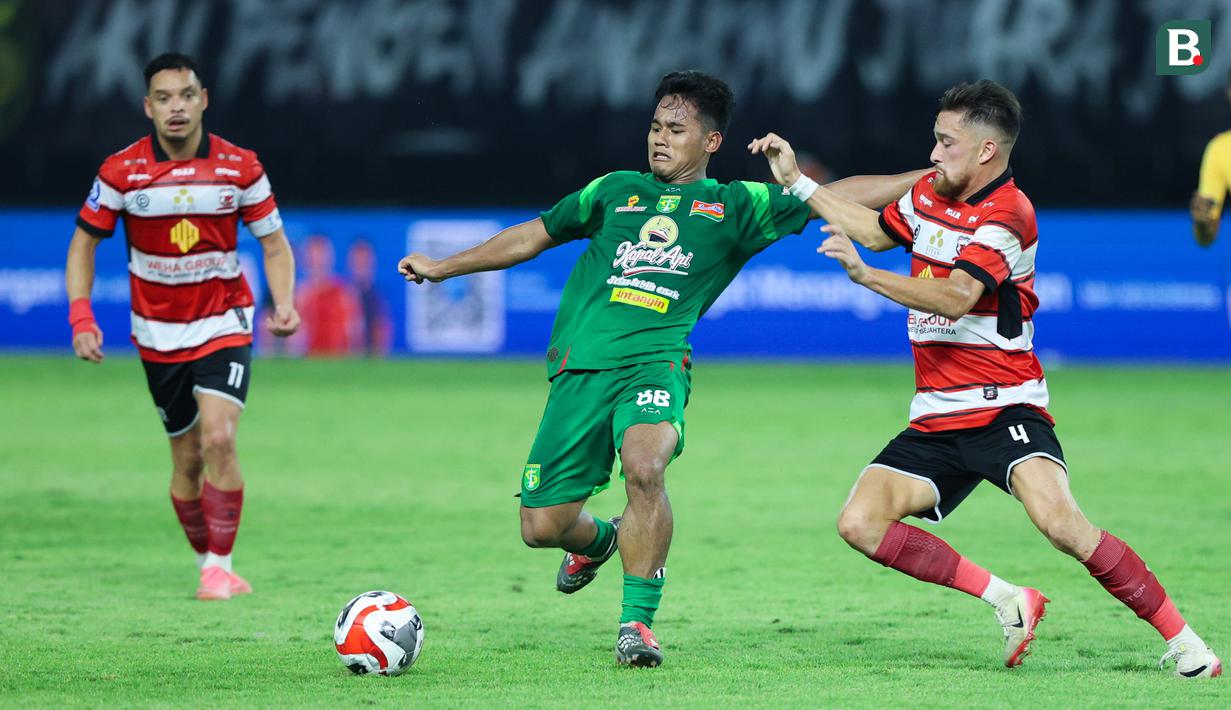 Pemain Persebaya Surabaya, Toni Firmansyah, berebut bola dengan pemain Madura United, Jordy Wehrmann pada lanjutan BRI Super League 2025/2026 di Stadion Gelora Bung Tomo Jumat (17/4/2026). (Bola.com/M Iqbal Ichsan)
