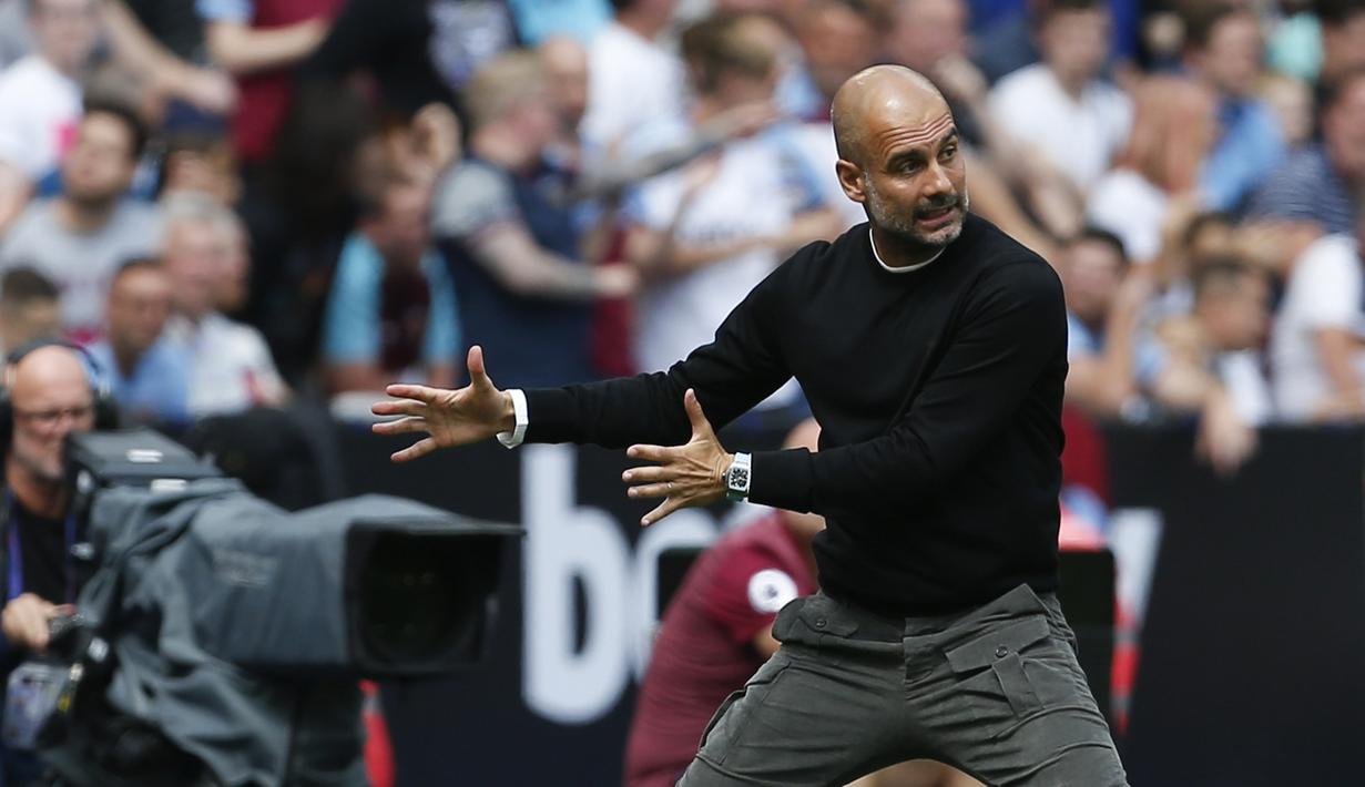 Pelatih Manchester City, Pep Guardiola, memberikan instruksi saat melawan West Ham pada laga Premier League di Stadion London, London, Sabtu (10/8). West Ham kalah 0-5 dari City. (AFP/Ian Kington)