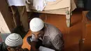 Keluarga dan kerabat berkumpul di depan jenazah Didi Petet di rumah duka kawasan Ciputat, Tangerang Selatan, Jumat (15/5/2015). Tampak sanak saudara membacakan doa di depan jenazah pria bernama asli Didi Widiatmoko tersebut. (Liputan6.com/Helmi Afandi)