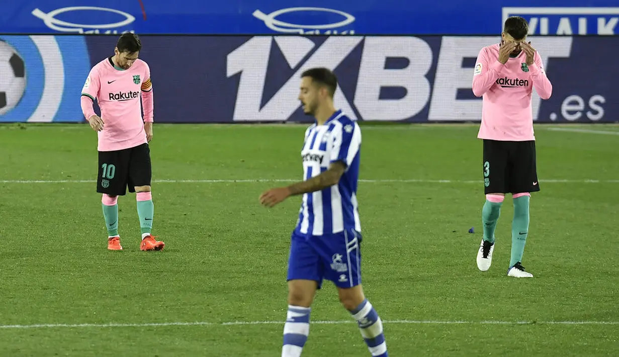 Pemain Barcelona, Lionel Messi dan Gerard Pique tampak kecewa usai ditahan imbang Alaves pada laga Liga Spanyol di Stadion Mendizorroza, Minggu (1/11/2020). Kedua tim bermain imbang 1-1. (AP Photo/Alvaro Barrientos)