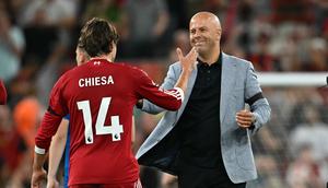 Pemain Liverpool, Federico Chiesa (kiri), merayakan kemenangan timnya atas Bournemouth bersama Arne Slot pada pekan 1 Premier League 2025/2026 di Anfied, Sabtu (16/8/2025) dini hari WIB. (Paul ELLIS / AFP)