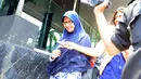 Athiyyah Laila tampak menghindari wartawan usai menjenguk suaminya. Ia hanya tersenyum ketika wartawan menyerbunya dengan aneka pertanyaan (Liputan6.com/Faisal R Syam).
