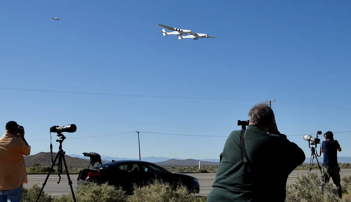 Pesawat terbesar di dunia, Stratolaunch, melakukan penerbangan pertamanya di Mojave, California, AS pada 13 April 2019. Pesawat ini memiliki dua badan terpisah yang disatukan sayap sepanjang 117 meter - seluas lapangan sepak bola Amerika. (REUTERS/Gene Blevins)