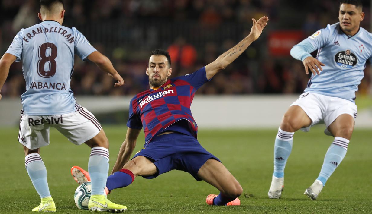 Gelandang Barcelona, Sergio Busquets berusaha merebut bola pemain Celta Vigo, Fran Beltran pada pertandingan lanjutan La Liga Spanyol di stadion Camp Nou (9/11/2019). Barcelona menang telak 4-1 atas Vigo. (AP Photo/Joan Monfort)
