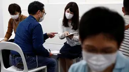 Seorang peserta pria berbincang dengan peserta wanita menggunakan masker dalam acara layanan kencan di Tokyo, Jepang, (16/10). Penggunaan masker ini untuk menghindari penyebaran penyakit saat layanan kencan singkat. (REUTERS/Kim Kyung-Hoon)