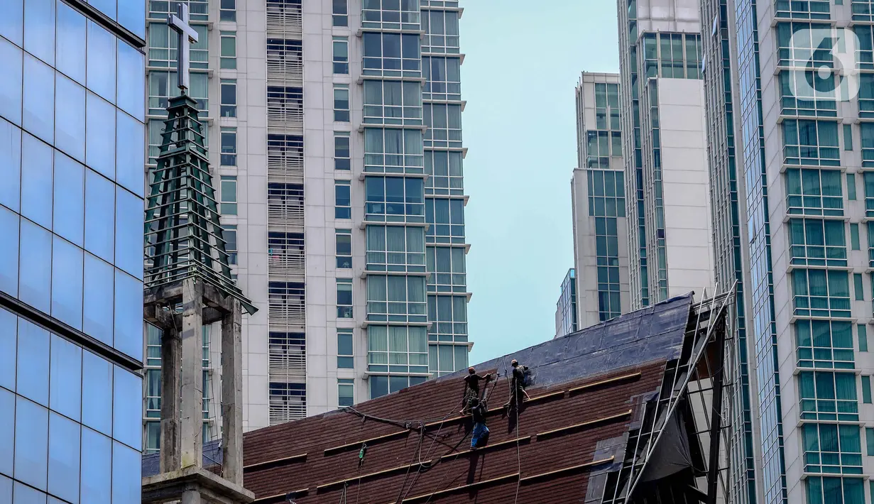 Aktivitas pekerja di atas atap gereja tanpa alat pengaman lengkap, Jakarta, Rabu (12/2/2020). Kemnaker mengatakan tingginya angka kecelakaan kerja di Indonesia disebabkan tidak maksimalnya penerapan K3 yang diatur dalam UU No1 Tahun 1970 tentang Keselamatan Kerja. (Liputan6.com/Faizal Fanani)