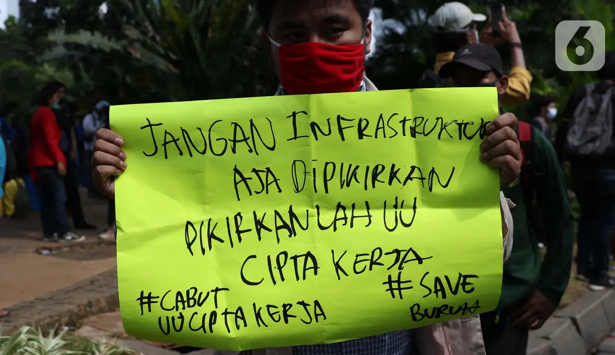 Seorang mahasiswa menunjukkan poster saat melakukan aksi unjuk rasa di sekitar kawasan Patung Kuda, Jalan Medan Merdeka Barat, Jakarta, Selasa (20/10/2020). Dalam aksinya, ratusan mahasiswa meminta pemerintah membatalkan pengesahan Omnibus Law UU Cipta Kerja. (Liputan6.com/Helmi Fithriansyah)